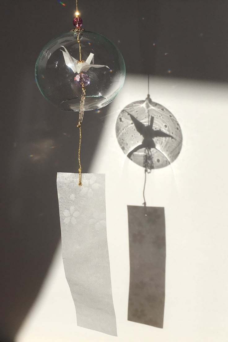 an ornament hanging from the side of a wall next to a piece of paper