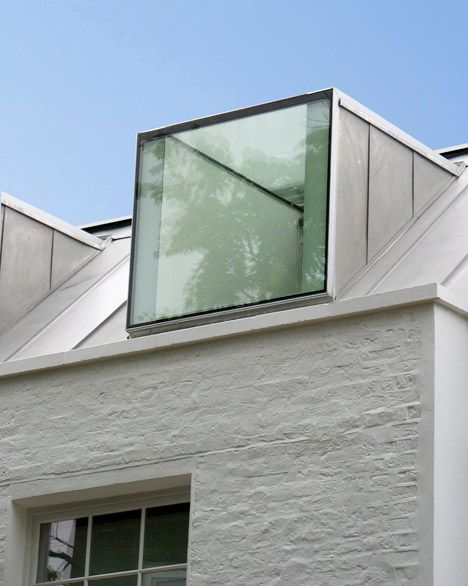 a white building with two windows and a skylight