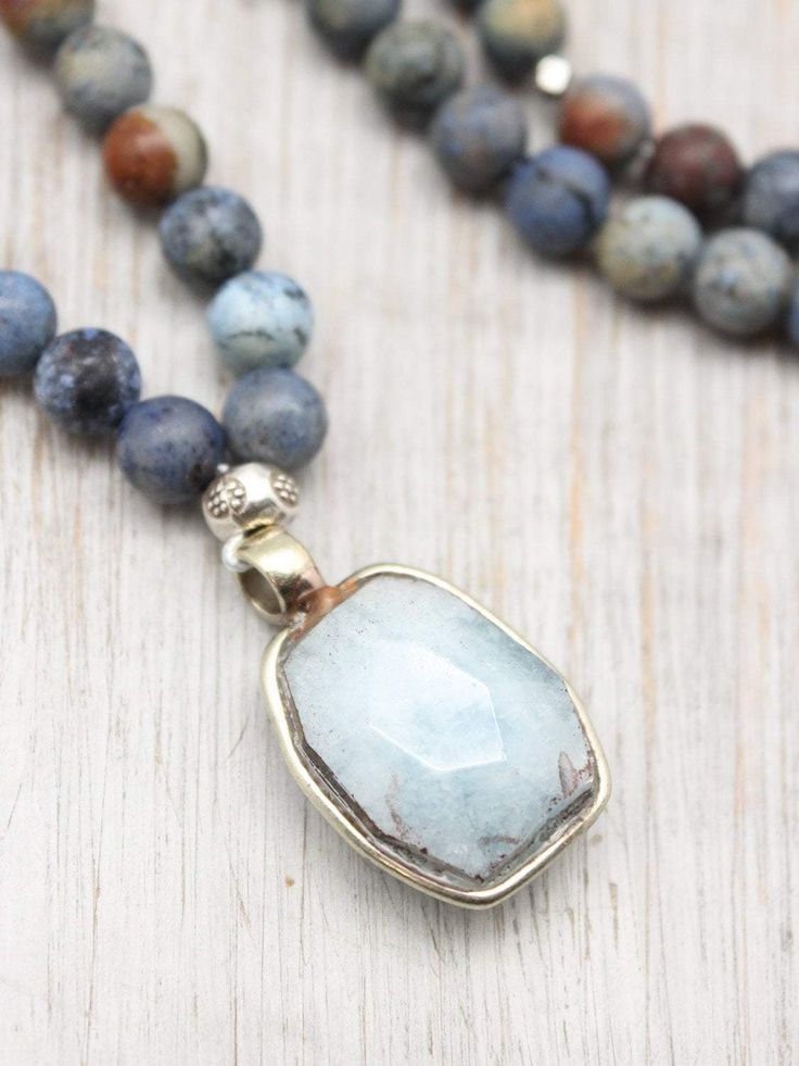 This truly exclusive 108 bead mala from our DharmaShop curated collection is designed to promote happiness and positive energy! Includes Aquamarine and matte Sunset Dumortierite beads with 98% pure Hill Tribe silver spacers from Thailand. A dainty heart charm and beautiful hand carved Aquamarine gemstone pendant complete the mala. The main focal point is the handmade faceted gemstone pendant from Nepal. Each Aquamarine pendant is entirely unique, making your mala one-of-a-kind! Aquamarine embodi Mala Bead Necklace, 108 Mala Beads, Aquamarine Pendant, Hill Tribe Silver, Aquamarine Beads, 108 Bead, Aquamarine Gemstone, Bead Jewelry, Mala Beads