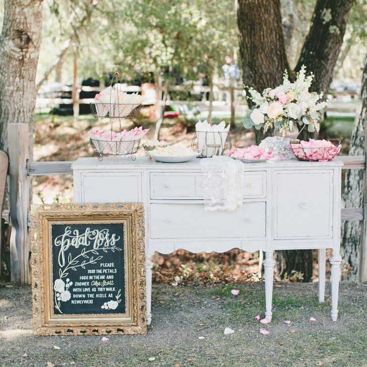 an old dresser is decorated with pink and white flowers, chalkboard sign for seating