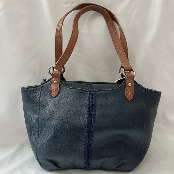 Genuine Leather Women's Satchel Tote Indigo/Navy With Brown Straps And Antique Silver Tone Hardware Main Zipper Closure With Front And Back Top Slip Pockets And One Back Zipper Pocket Interior Contains Back Wall Slip Pocket, Zipper Pocket And Two Front Wall Multi-Functional Pockets Bag Dimensions Are 16.5" L X 4" W X 10" H. Strap Drop: Up To 10" Care: To Clean, Use A Water-Based Leather Cleaner And Moisturizer; Use A Protective Spray To Protect The Leather Surface Navy Leather Bag With Handles, Blue Leather Shoulder Bag With Leather Lining, Navy Leather Shoulder Bag For Everyday, Everyday Blue Shoulder Bag With Leather Trim, Blue Shoulder Bag With Leather Trim For Everyday, Blue Faux Leather Shoulder Bag For Everyday Use, Blue Leather Shoulder Bag With Leather Trim, Navy Leather Shopping Bag, Chic Blue Bags With Leather Trim