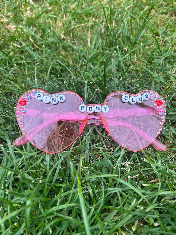 Chappell Roan inspired handmade sunglasses Perfect for concerts or festivals if you want a specific charm state it in the personalisation box otherwise it will be red lips Can be customised - no more than 15 characters Please note that not all sunglasses will not be identical to the pictures due to it being handmade and therefore there may be slight imperfections  I do not accept any refunds or returns so if you have any problems message me and Ill try and resolve it in another way if possible. Trendy Plastic Sunglasses For Music Festival, Trendy Handmade Sunglasses For Party, Trendy Handmade Sunglasses For Parties, Trendy Sunglasses With Mirrored Lenses For Concerts, Retro Plastic Festival Sunglasses, Trendy Red Sunglasses As Gift, Red Tinted Sunglasses As A Gift, Red Tinted Lenses Sunglasses As Gift, Festival Fun Sunglasses With Gradient Lenses