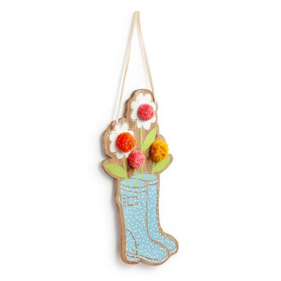 a wooden hanging decoration with flowers in a boot and polka dot dots on the bottom