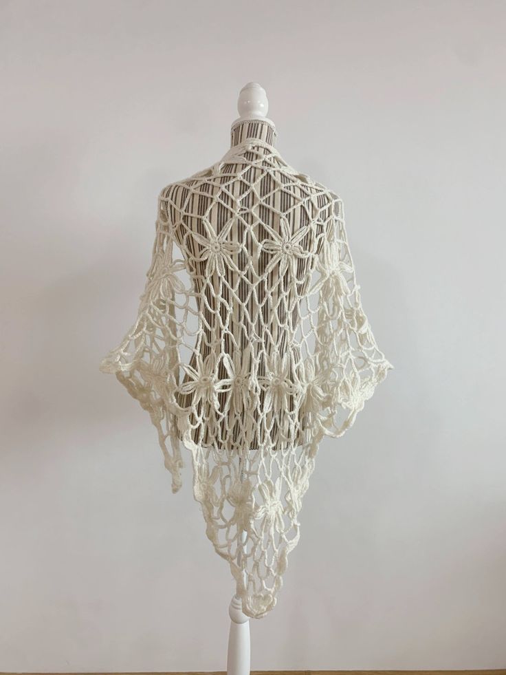 "This is a beautiful vintage soft mohair crochet lace shawl in off white color. This fluffy lace shawl is made of soft warm yarn which will keep you cozy during the winter days and yet it will make you feel gorgeously stylish. This bohemian shawl has a fishnet floral pattern. Perfect mohair wrap for the fall/ winter season. This boho shawl will add a pop of romantic cottagecore style to your outfit.   This women triangle shawl is the perfect gift for your sister, mother or grandmother. Era: Y2K Condition: This mohair shawl is in great vintage condition with some signs of wear. Perhaps the fabric was fluffier before, but it still looks awesome.  Measurements:  Length: 65\" / 165 cm  Width: 41.3\"  /105 cm  Colors: off white Material: not marked feels like mohair wool Shipping: I will ship y Handmade White Shawl For Spring, Bohemian Lace Shawl With Lace Work, White Handmade Shawl For Spring, Traditional White Summer Shawl, Traditional White Shawl For Summer, Bohemian Cream Crochet Lace Shawl, White Bohemian Shawl For The Beach, White Bohemian Shawl For Beach, Fitted Bohemian Shawl For Wedding