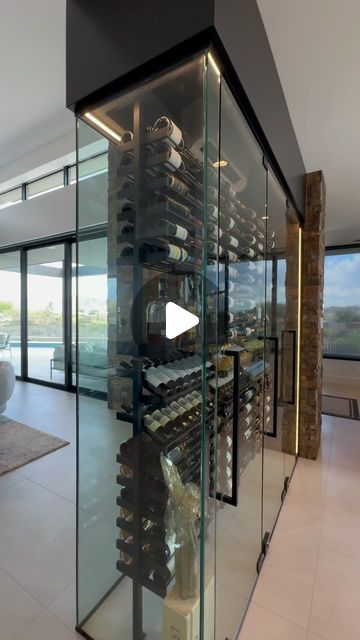 a glass wine cellar in the middle of a living room