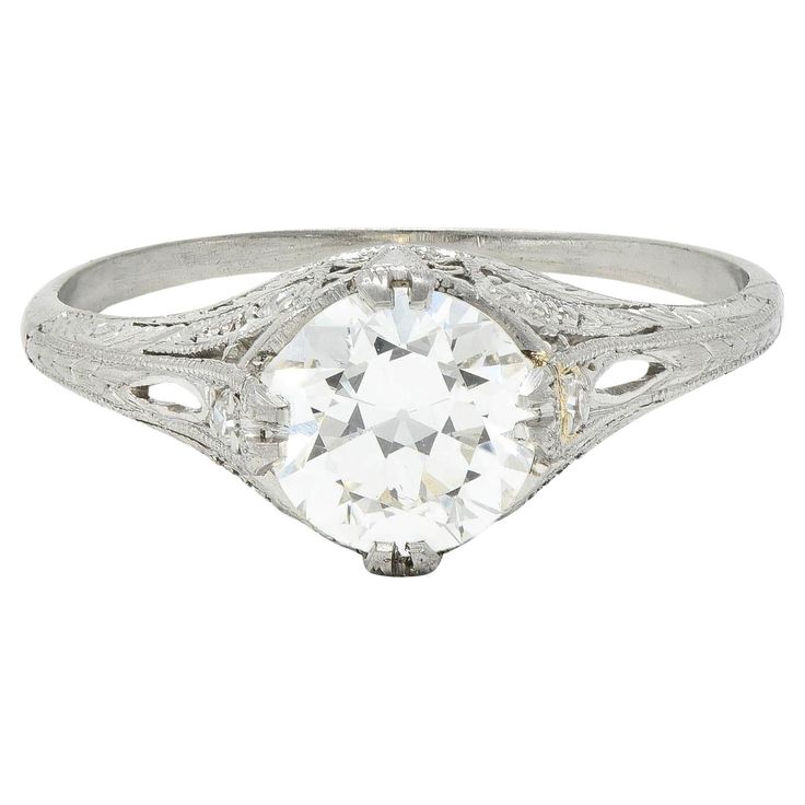 an antique style diamond ring with filigrees on the shoulders and sides, set in