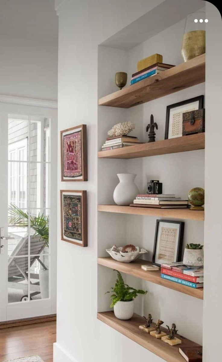 some shelves with books and pictures on them in a room next to a door that leads to a patio