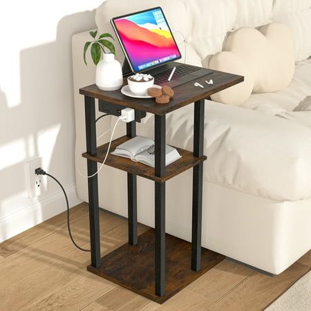 a laptop computer sitting on top of a wooden table next to a white couch in a living room