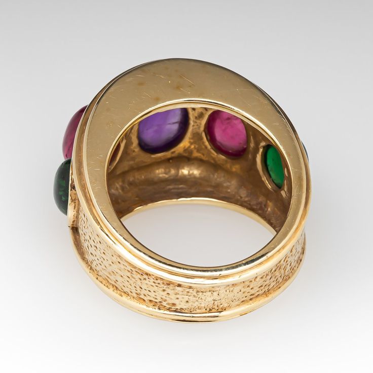 This beautiful ring is centered with one (1), bezel set, oval cabochon cut natural amethyst and is flanked to each side by one (1), bezel set, oval cabochon cut natural pink tourmaline and one (1), bezel set, oval cabochon cut natural green tourmaline. The ring measures 16.1mm at the top, rises 9.0mm above the finger, tapering to 7.1mm wide and 1.5mm thick at the base of the shank. It is currently a size 6.5. Yellow Gold Multi-stone Cabochons For Fine Jewelry, Yellow Gold Multi-stone Cabochons Fine Jewelry, Vintage Oval Cabochon Gemstones, Formal Cabochon Round Gemstone, Luxury Multi-stone Oval Cabochons, Luxury Round Cabochons With Bezel Setting, Formal Round Cabochons With Bezel Setting, Luxury Cabochons With Bezel Setting, Formal Rings With Bezel Setting And Oval Cabochon