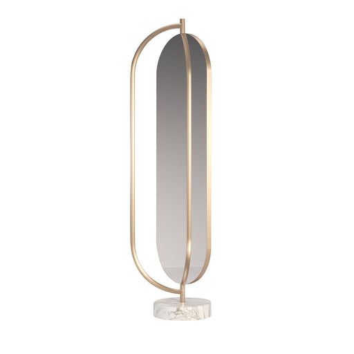 a white and gold table lamp with an oval mirror on the top, next to a round metal stand