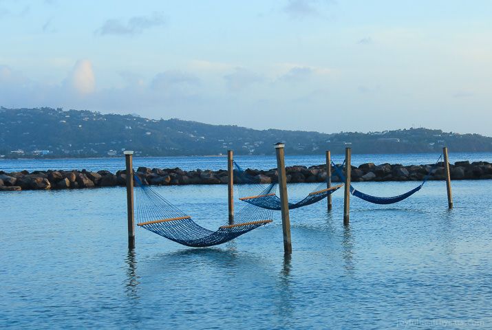 two hammocks are in the water next to some poles