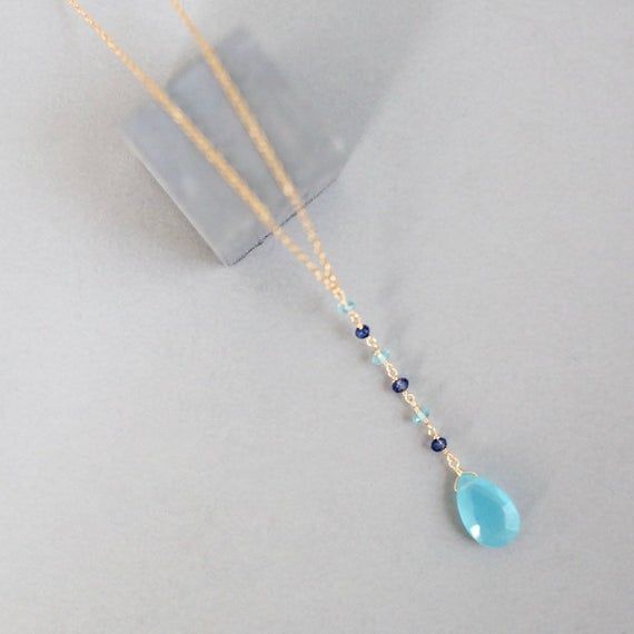 Free shipping on our dainty blue chalcedony y pendant necklace for women. Mixed with iolite and aquamarine gemstone accent stones. Makes an excellent graduation gift, anniversary gift or gift for mom.- Adjustable chain length. Can be extended from 16" up to 18"- Total necklace length, with 2" pendant drop, is 18-20"- Spring ring clasp, - Chain, pendant and clasp are all 14k gold plated over exquisite .925 fine Italian sterling silver. Our unique gold plating technique is tarnish resistant.- Hand Elegant Light Blue Necklaces With Natural Stones, Blue Gemstone Wedding Necklace, Elegant Light Blue Necklace With Natural Stones, Blue Aquamarine Briolette Necklace, Gift Blue Drop Necklace With Natural Stones, Elegant Blue Crystal Necklace With Gemstone Accents, Blue Briolette Necklace For Wedding, Elegant Light Blue Crystal Necklace For Gift, Elegant Light Blue Crystal Necklace Gift