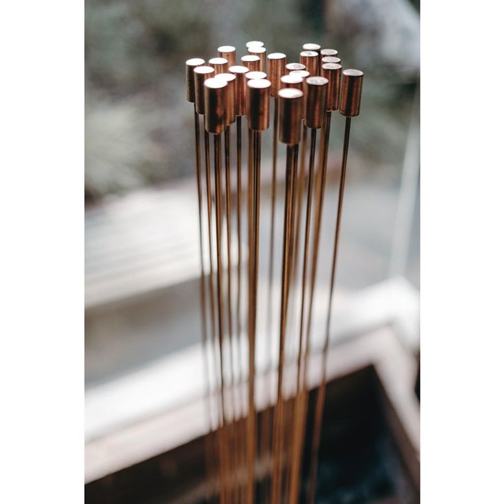 four wooden sticks with white dots on them in front of a glass window sill