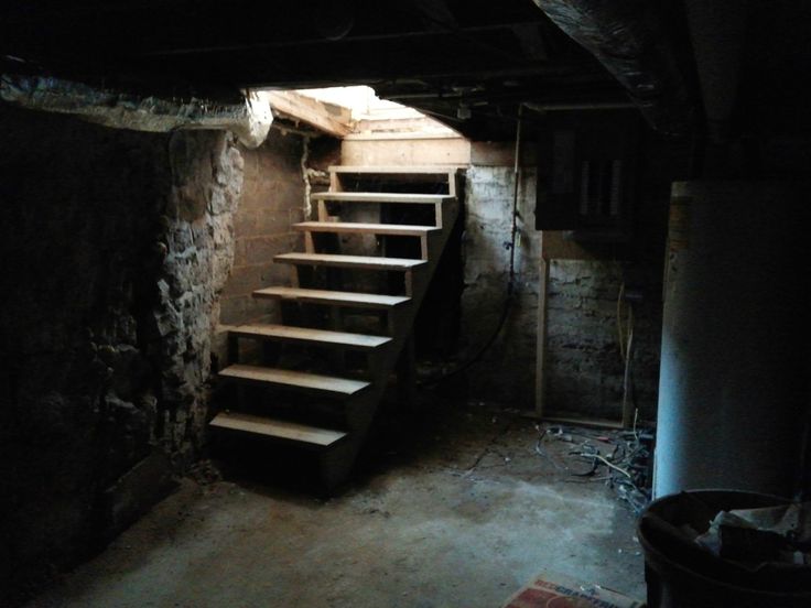 an old basement with stairs leading up to the top floor and light coming from above