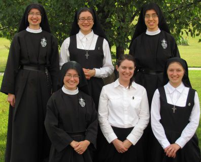 a group of women standing next to each other in front of a tree