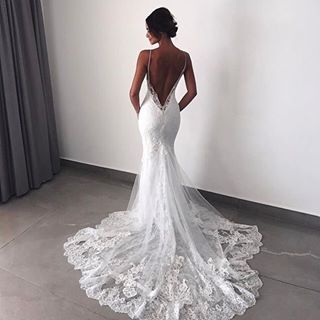 the back of a woman's wedding dress is seen in this image from behind