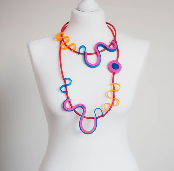 a white mannequin with a multicolored necklace on it