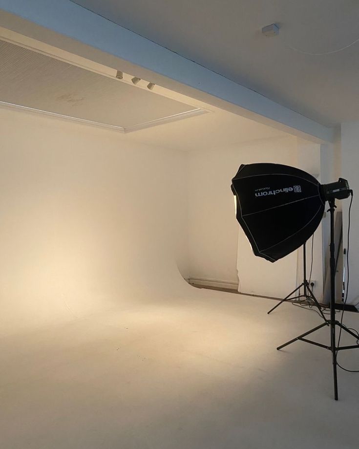 an empty white room with lighting equipment in it