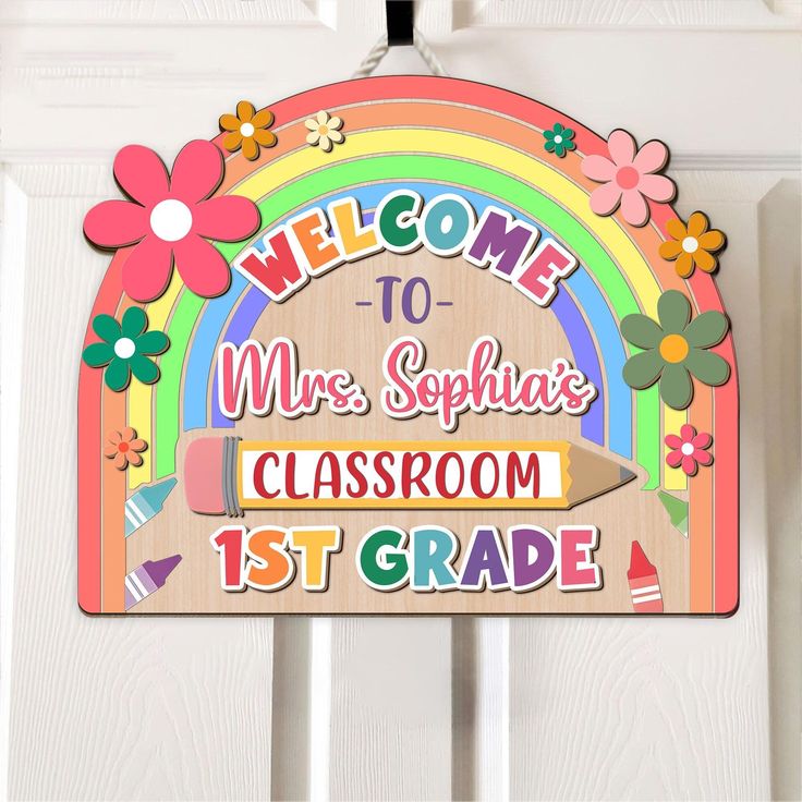 a welcome sign hanging on the front door of a school classroom with flowers and rainbows