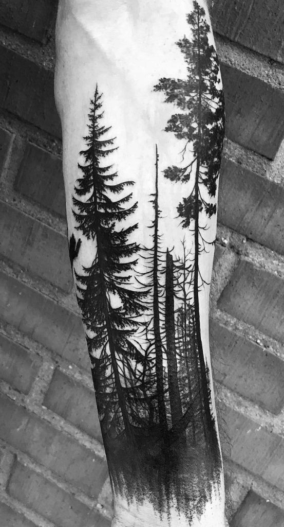 a man's leg with trees and birds on it, in black and white