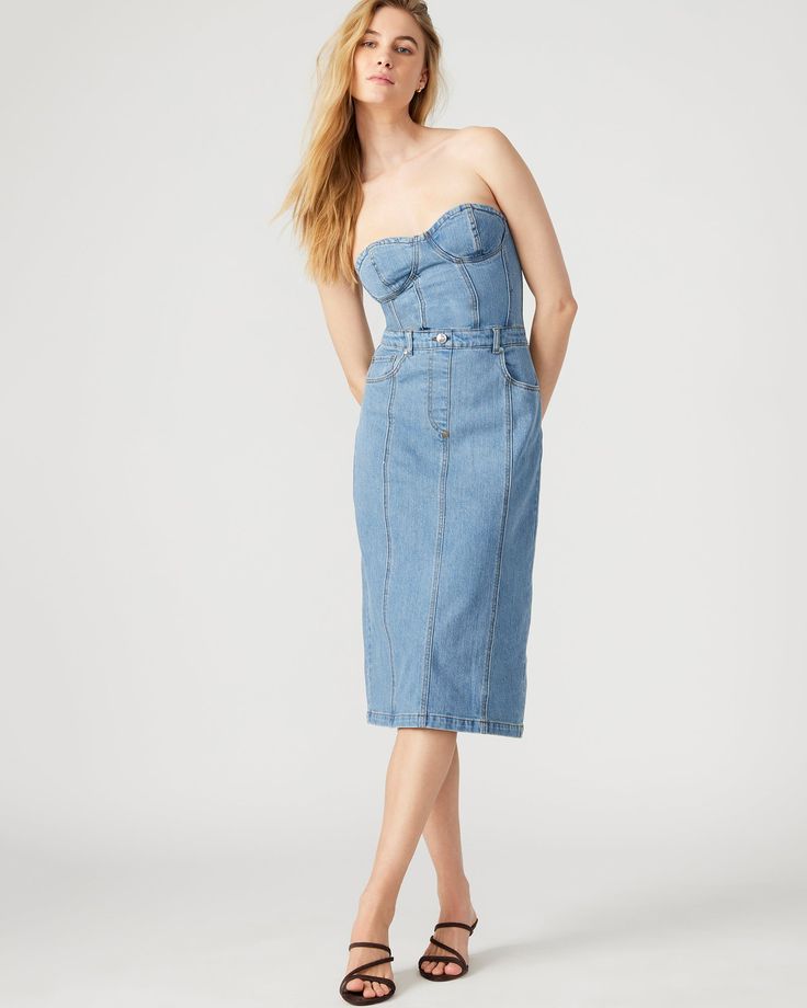 This denim dress combines the casual appeal of blue denim with the sophistication of a bustier top and pencil skirt. Perfect for a cocktail event or dinner out, the midi length offers just the right amount of coverage while still showing off your curves. Bustier denim midi dress Pencil skirt bottom Back zipper closure Length: 35.75" 98% cotton 2% spandex Hand wash Emma is 5ft 10in and is wearing a size small Imported Fitted Midi Corset Dress For Spring, Spring Knee-length Bodycon Corset Dress, Spring Season Bodycon Knee-length Corset Dress, Spring Bodycon Knee-length Corset Dress, Chic Knee-length Spring Corset Dress, Chic Knee-length Corset Dress For Spring, Chic Spring Knee-length Corset Dress, Elegant Fitted Denim Blue Denim Dress, Fitted Denim Midi Dress For Date Night