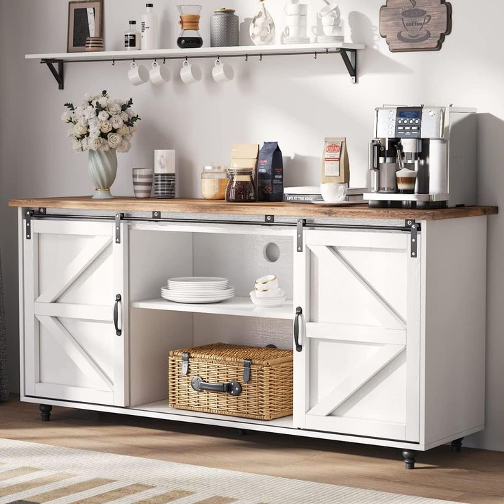 a white cabinet with open doors and shelves on the wall next to a basket filled with flowers