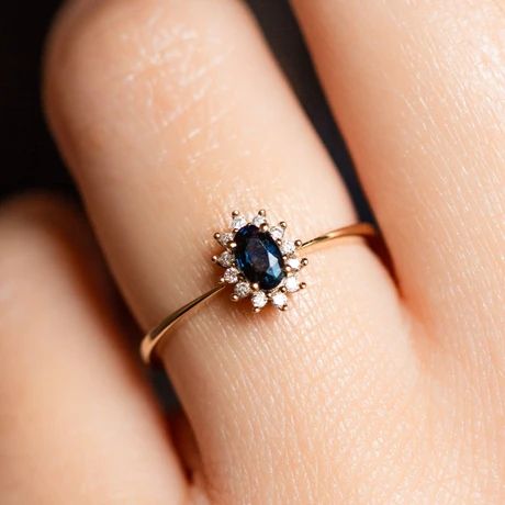 a woman's hand with a diamond and blue sapphire ring on her left finger