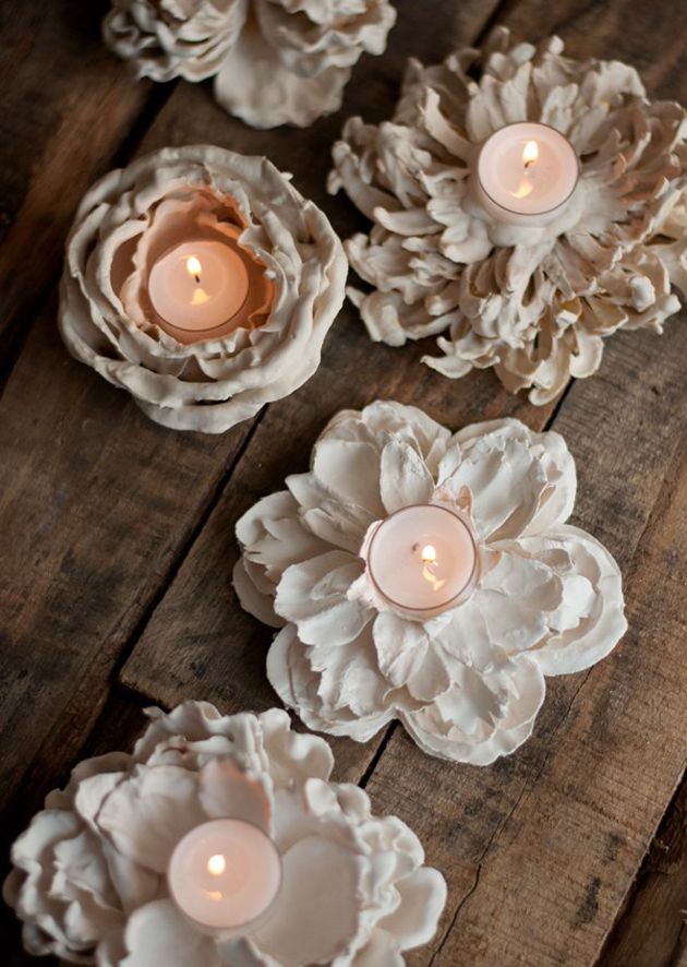 some white flowers and candles are on a wooden table with the words merken above them