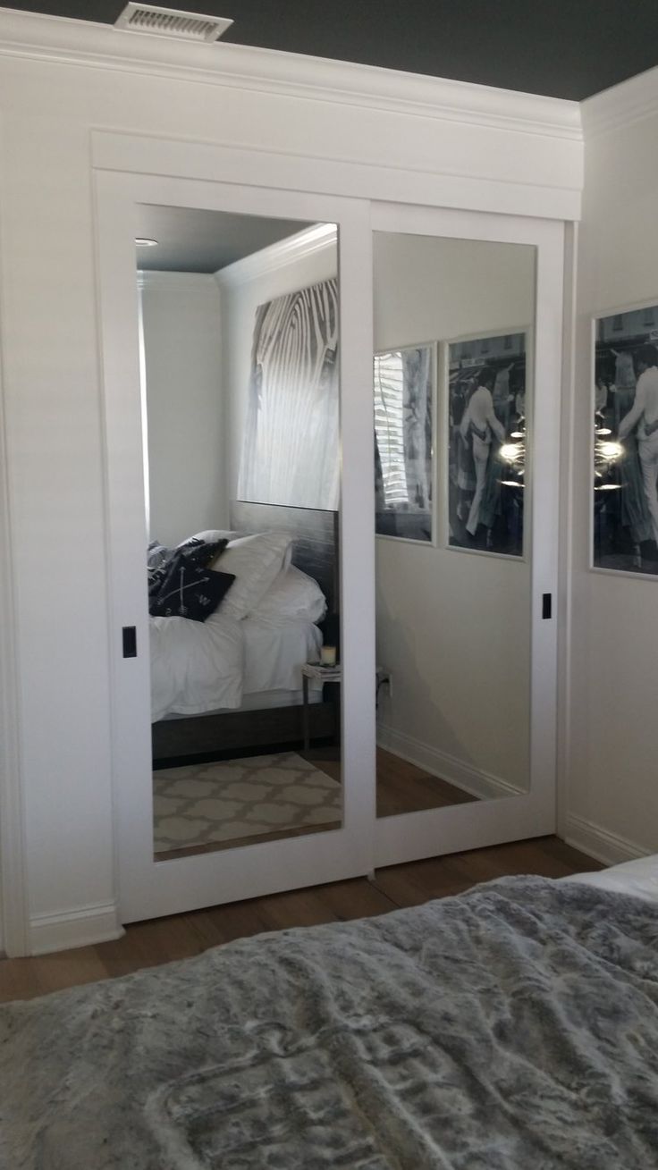 a bedroom with mirrored closet doors and pictures on the wall