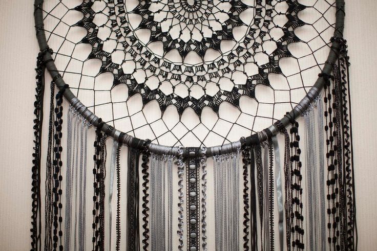 a black and white dream catcher hanging on the wall