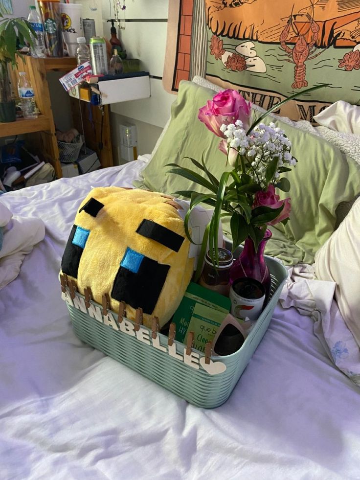 a bed with a basket filled with flowers and stuffed animals sitting on top of it