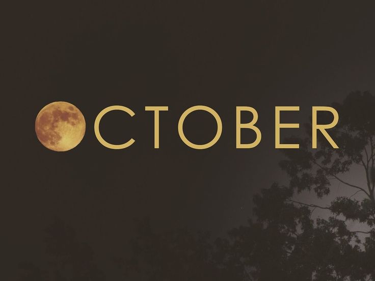 the words october are lit up at night in front of a full moon and trees