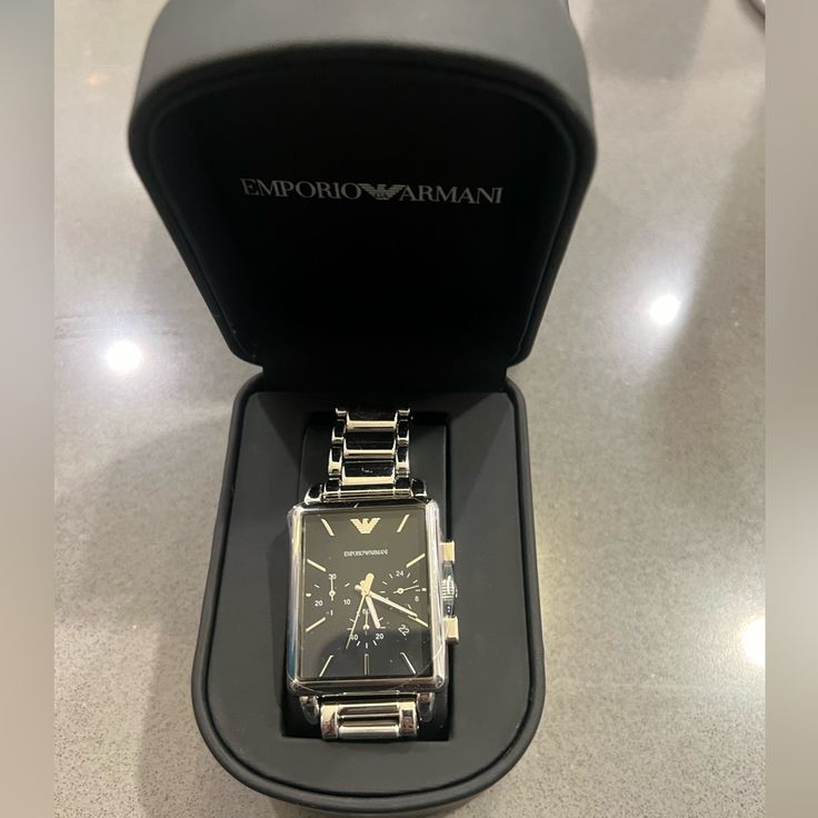 Nwt Men’s Emporio Armani Watch Brand New, Never Been Worn Black Rectangular Face Needs A New Battery Comes With Original Watch Box And Gifting Box Stainless Steel Case With A Stainless Steel Bracelet. Fixed Stainless Steel Bezel. Black Dial With Silver-Tone Hands And Index Hour Markers. The Emporio Armani Logo Appears At The 12 O'clock Position. Silver Timeless Watch Bands For Business, Timeless Silver Watch Bands For Business, Designer Black Chronograph Watch For Formal Occasions, Designer Black Chronograph Watch For Formal Events, Formal Stainless Steel Watch Bands With Clasp, Formal Stainless Steel Watch Bands With Stainless Steel Clasp, Rectangular Chronograph Watch For Business, Designer Analog Watch With Rectangular Dial, Business Chronograph Watch With Rectangular Face