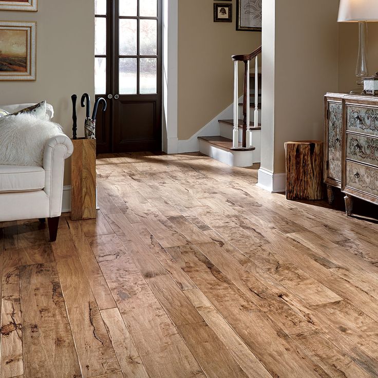 a living room with hard wood floors and white furniture