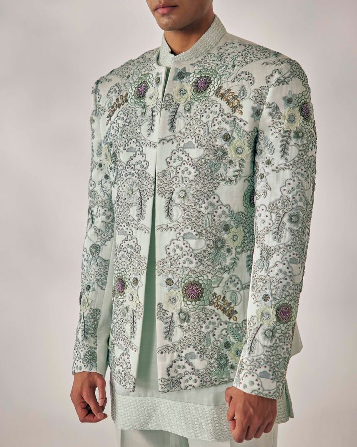 Slow Blue Short Jacket Set | Jatin Malik Elevate your style with our hand-embroidered short jacket adorned with delicate appliqué, organza flowers, and French knots. Paired seamlessly with a matching color Linen silk kurta set featuring pintuck details and tapered trousers, this ensemble exudes elegance and sophistication, perfect for any special occasion. Included in purchase: Short Jacket, kurta, trouser Product Specification Color: Hazy blue Fabric: Linen Silk Occasion: Engagement, Wedding, Bridal, Reception Style: Short Jacket, kurta, trouser Care: Dry Clean Work: Hand Embroidery Customization options:Can be customized in any color or style Note: A stylist will contact you to confirm measurements after your order is placed.Estimated delivery time: 4 -6 weeks (Variation in color, fabric Designer Spring Formal Kurta, Designer Fitted Cotton Silk Sets, Designer Semi-formal Sets For Diwali, Designer Bandhgala For Spring Festivals, Designer Sets With Resham Embroidery For Spring, Designer Bandhgala With Zari Work For Spring, Designer Cotton Silk Sets For Eid, Designer Festive Cotton Silk Set, Designer Spring Sherwani With Zari Work