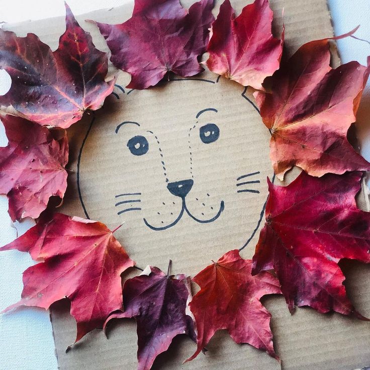 a paper plate with leaves and a lion face on it's face is made out of cardboard