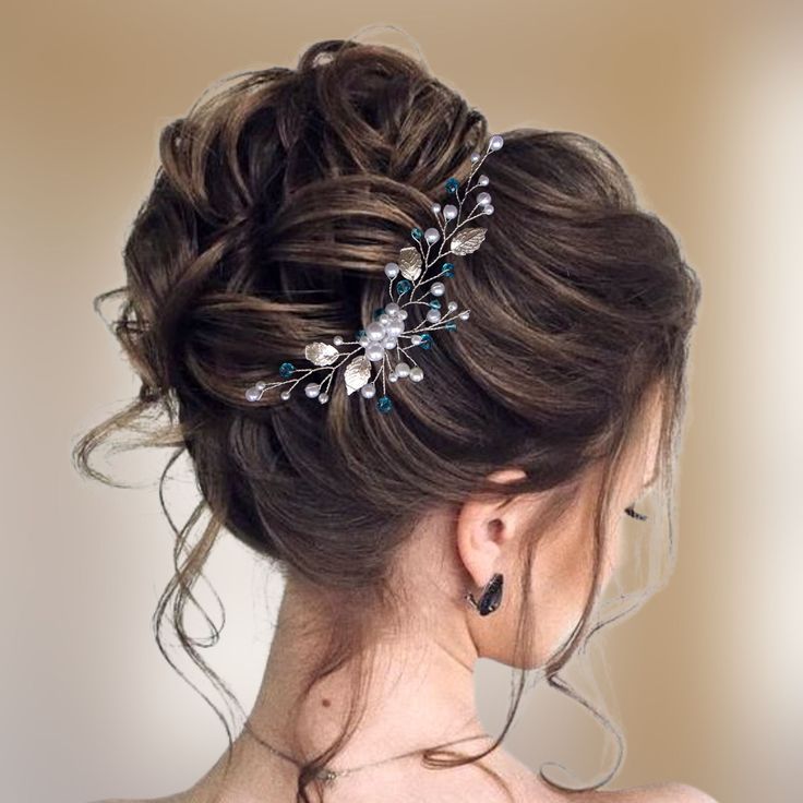 a woman wearing a wedding hair comb with flowers in it's back, looking to the side