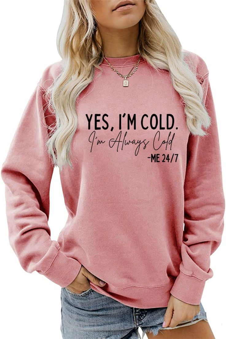 a woman wearing a pink sweatshirt with the words yes i'm cold on it