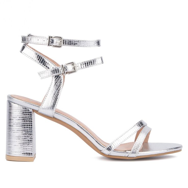 Stand out on your night out with the Laina sandal, featuring a striking lizard-embossed metallic finish that catches the light beautifully. The double ankle strap design adds a modern touch, ensuring both style and a secure fit. Ideal for pairing with a sleek pant or sheath dress, the Laina sandal elevates your evening look with its eye-catching shine and sophisticated silhouette. Make a bold statement and step confidently into the night with this chic and glamorous footwear choice. Metallic Ankle Strap Heels With Buckle Closure, Metallic Heels With Heel Strap And Single Toe Strap, Metallic High Heel Shoes With Buckle Closure, Metallic High Heels With Buckle Closure, Metallic Sandals With Wrapped Block Heel, Metallic Sandals With Wrapped Heel And Ankle Strap, Formal Shimmer Sandals With Block Heel, Silver Sandals With Reinforced Heel For Summer, Silver Sandals With Reinforced Block Heel