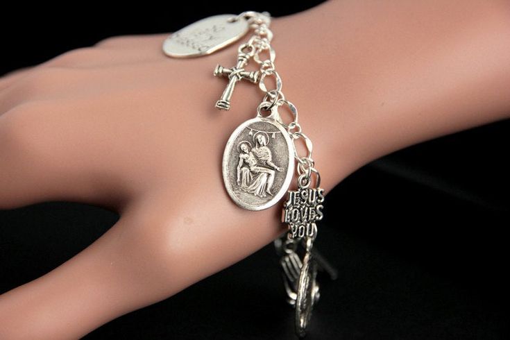 "A Pieta medal combined with a collection of silver plated Christian theme charms have been dispersed around a shimmering silver plated bracelet chain in this handmade charm bracelet. This religious charm bracelet is then completed with a lobster clasp and a 1/2 inch of chain at the end for adjustable sizing. ● Bracelet Styles ● Style #1 - Charms in this bracelet include a \"Christ Carrying the Cross\" charm, praying hands charm, a \"So Very Blessed\" charm, a Jesus fish charm, a \"Jesus loves y Symbolic Silver Rosary Bracelet For Gifts, Symbolic Silver Rosary Bracelet Gift, Silver Symbolic Rosary Bracelet As Gift, Symbolic Silver Rosary Bracelet, Engraved Silver Rosary Bracelet As Gift, Vintage Silver Rosary Bracelet As Gift, Silver Rosary Bracelet With Charms As Gift, Nickel Free Silver Metal Rosary Bracelet, Nickel-free Silver Metal Rosary Bracelet