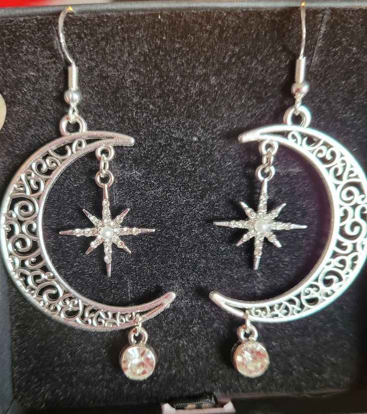 Stunning crescent moon with sparkling star and rhinestone drop earrings.  Sterling silver ear hook to protect your ears Unique and sparkling earrings Dangle Crystal Alloy Earrings, Silver Star-shaped Alloy Jewelry, Silver Alloy Crystal Earrings, Celestial Silver Earrings With Star Charm, Elegant Metal Earrings With Star Charm, Silver Star Crystal Earrings, Silver Star-shaped Crystal Earrings For Pierced Ears, Silver Star Crystal Earrings For Pierced Ears, Silver Crescent Crystal Earrings For Pierced Ears