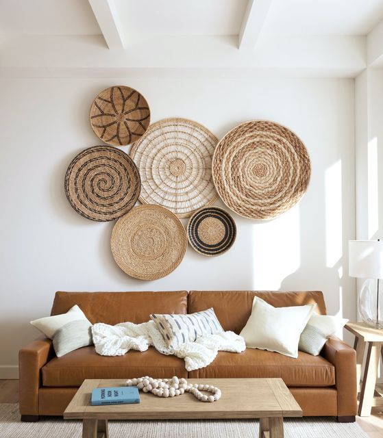 a living room filled with furniture and lots of wicker baskets hanging on the wall