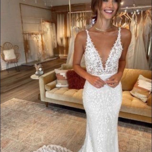 a woman standing in front of a couch wearing a wedding dress