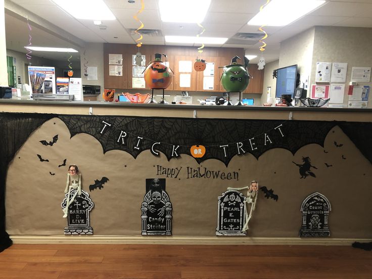 an office decorated for halloween with decorations on the front desk and behind it is a trick treat bar