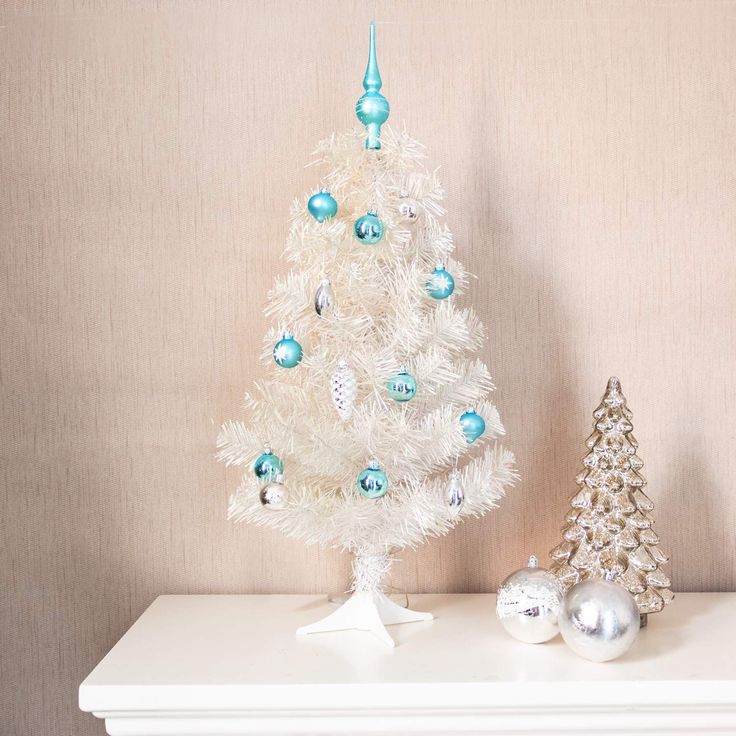 a white christmas tree with blue and silver ornaments