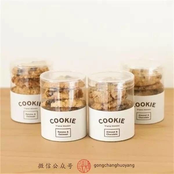 four jars filled with cookies sitting on top of a wooden table