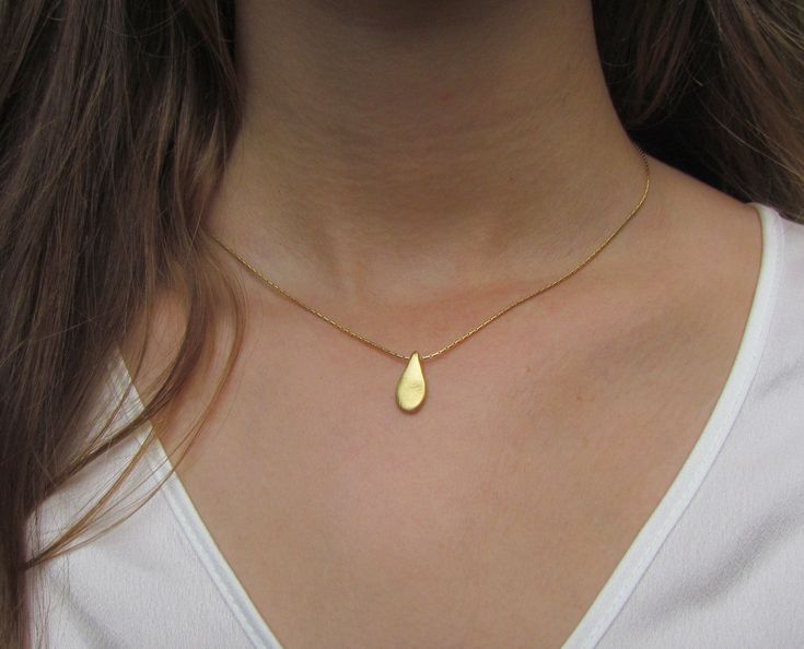 "This hand made teardrop pendant necklace has an effortless, earthy allure. The matte 18k gold plated brass pendant hangs at the base of a delicate 14k gold filled chain. This is the perfect necklace to pair with any casual outfit adding a bohemian vibe. Wear this alone, or layer it with your other favorites for a personalized eclectic look. ❉ F A C T S total length : 16\"/ 42 cm teardrop length: 1\"/ 2.54 cm teardrop width: 0.45\"/ 1.1 cm You will receive the necklace in a gift box ready to be Minimalist Teardrop Pendant As A Gift, Minimalist Teardrop Pendant For Gift, Minimalist Teardrop Pendant Drop Gift, Minimalist Gold Pear Drop Necklace, Gold Pear-shaped Drop Necklace For Gift, Gold Teardrop Necklace With Delicate Chain, Everyday Delicate Teardrop Drop Necklace, Gold Teardrop Drop Necklace In Dainty Style, Gold Teardrop Drop Necklace For Gift