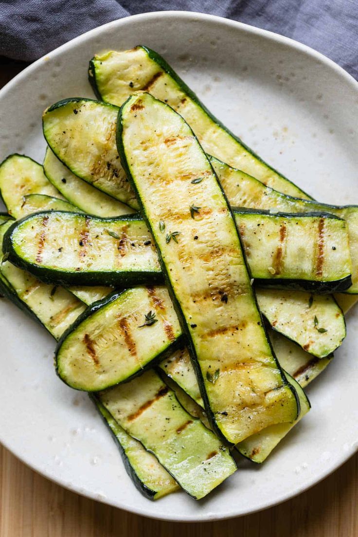 grilled zucchini in a white bowl on a wooden table