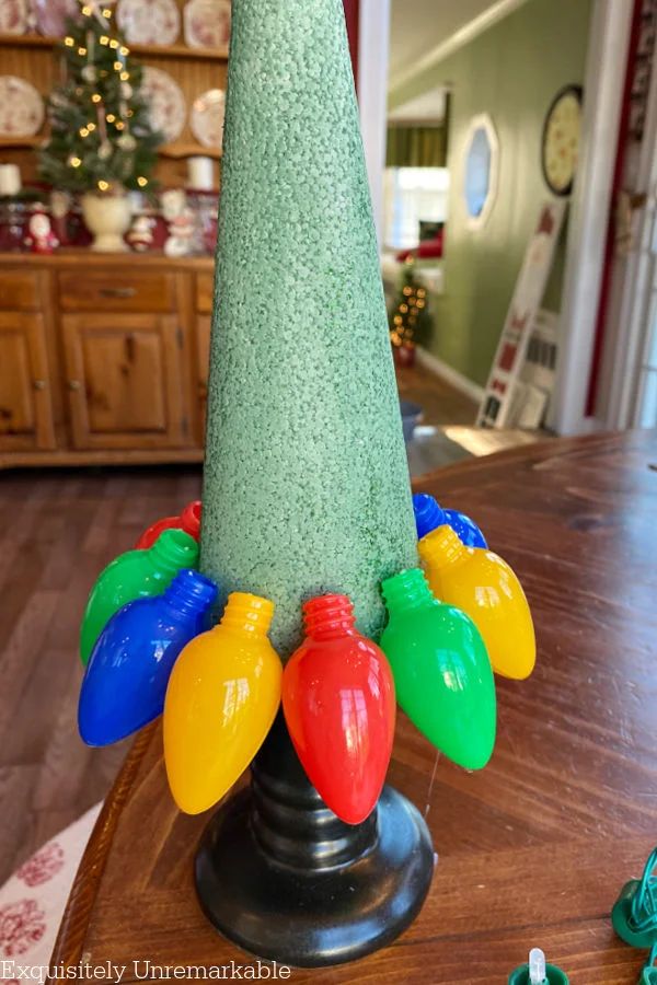 a christmas tree made out of plastic lights on top of a wooden table in a living room