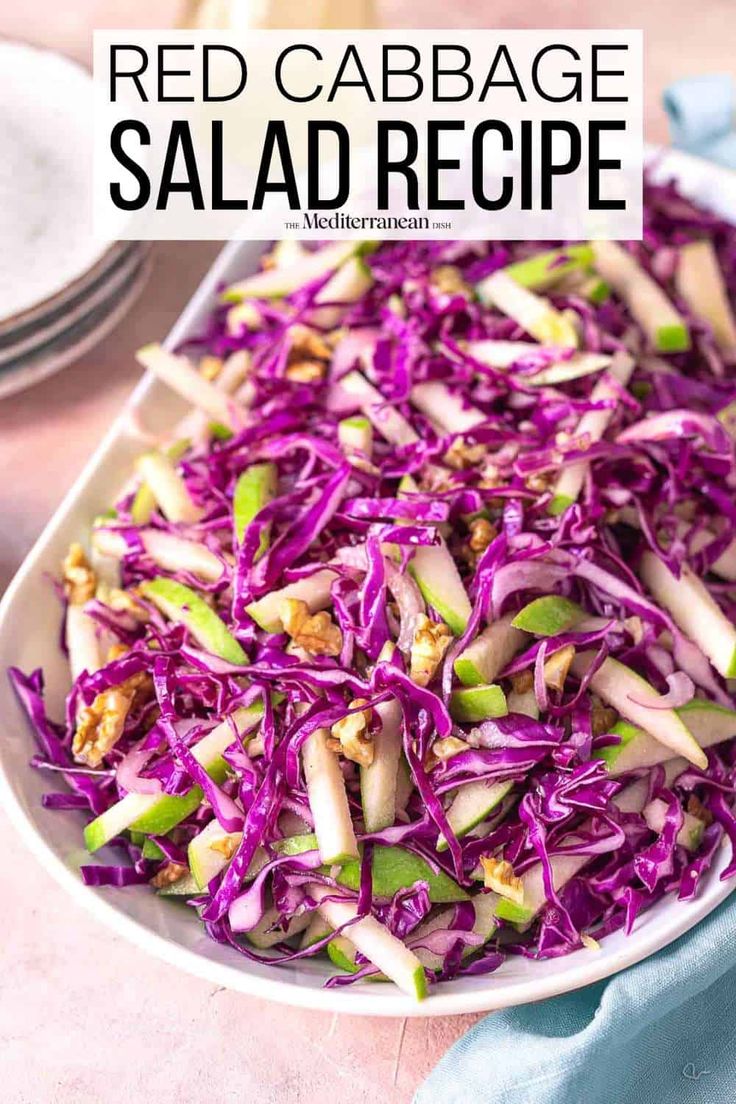 red cabbage salad in a white serving dish on a table with blue napkin and silverware